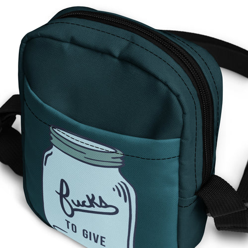 Top view of a crossbody bag with a mason jar that says fucks to give and is empty